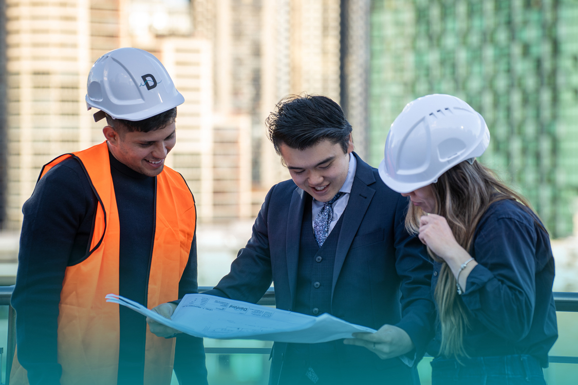 Three Danford College construction and trade students reviewing building plans together