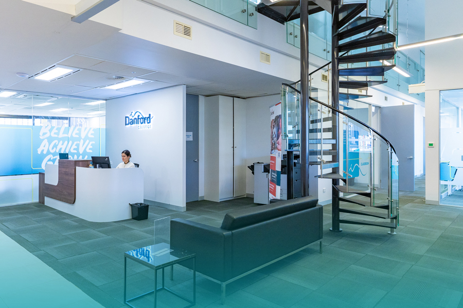 The Danford College reception area with a spiral staircase and lounge seating
