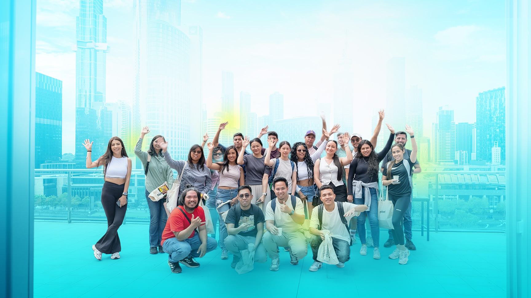 A large group of Danford College students posing together on a rooftop with the Melbourne skyline behind them