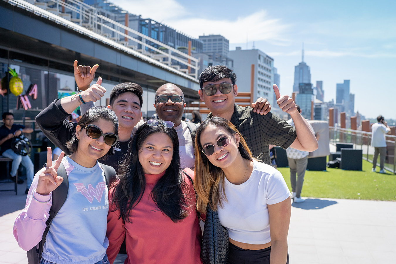 Danford College students celebrating together at a rooftop event with the Melbourne skyline behind them