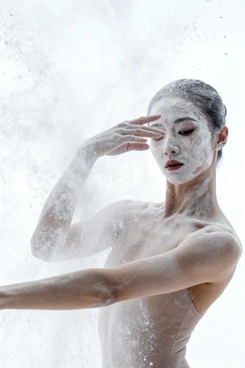 Fine powder captured in motion around a fashion portrait subject.