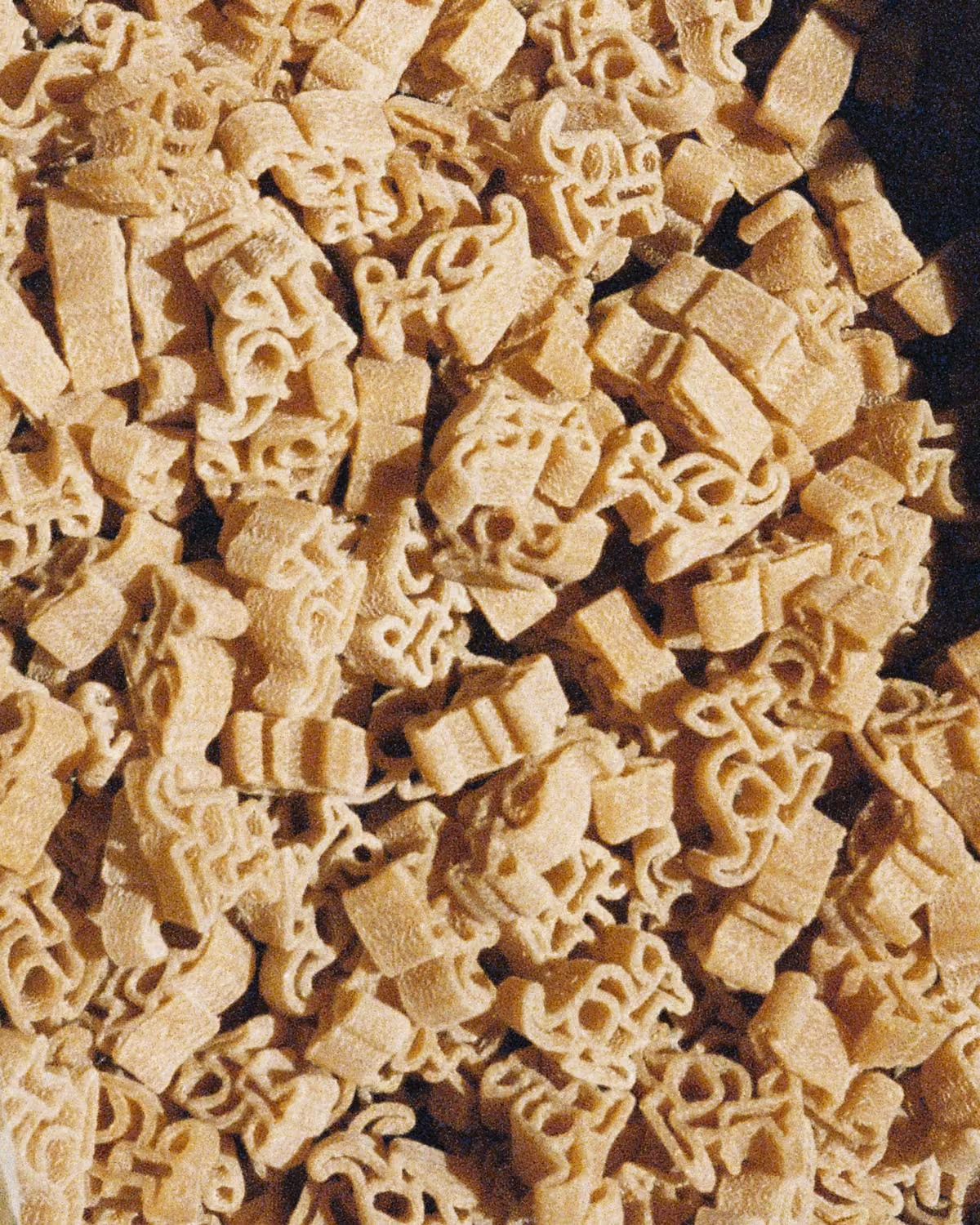 Close-up of uncooked beige kangaroo pasta shapes.
