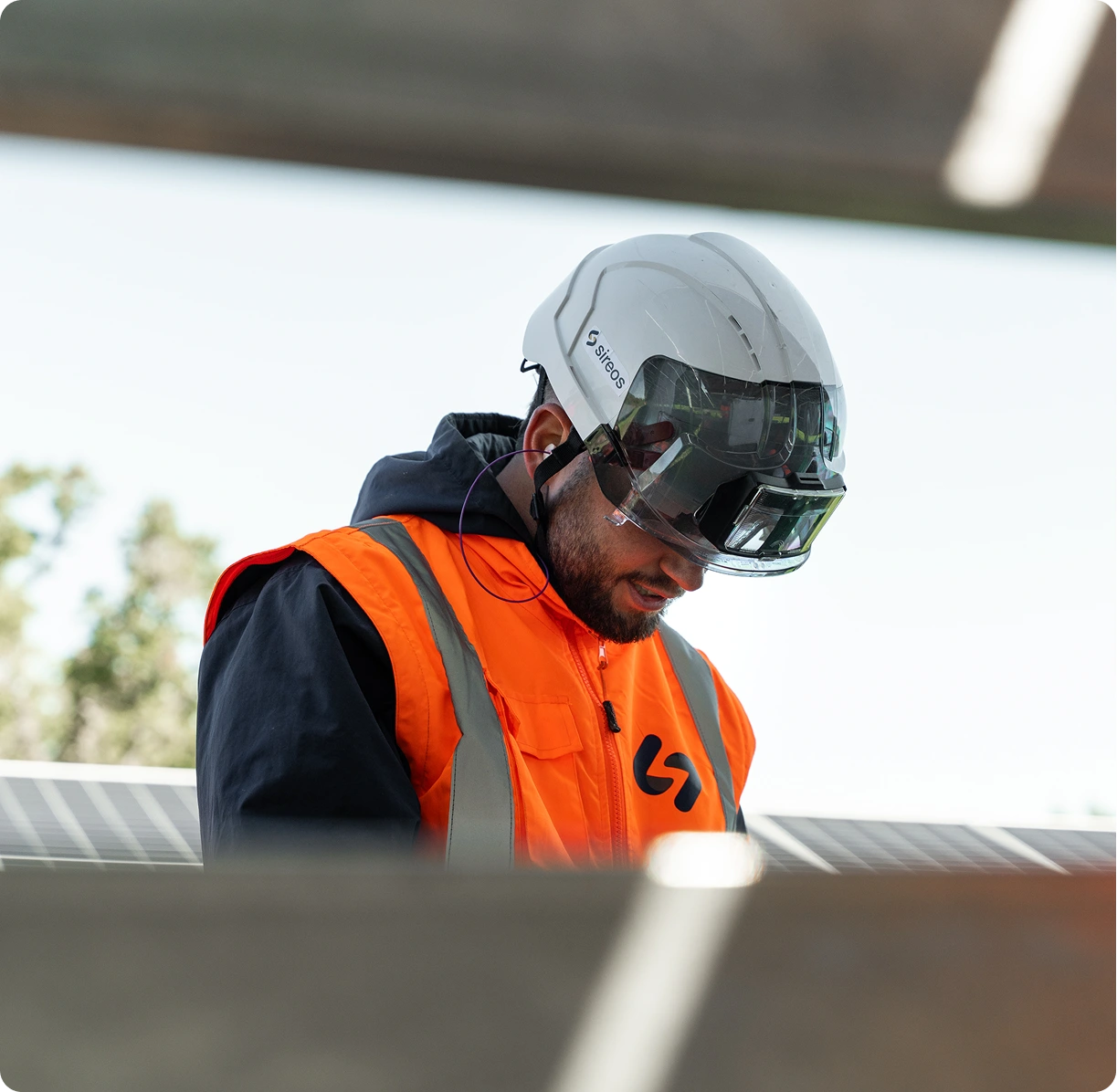 Technicien Sireos casqué inspectant un panneau solaire