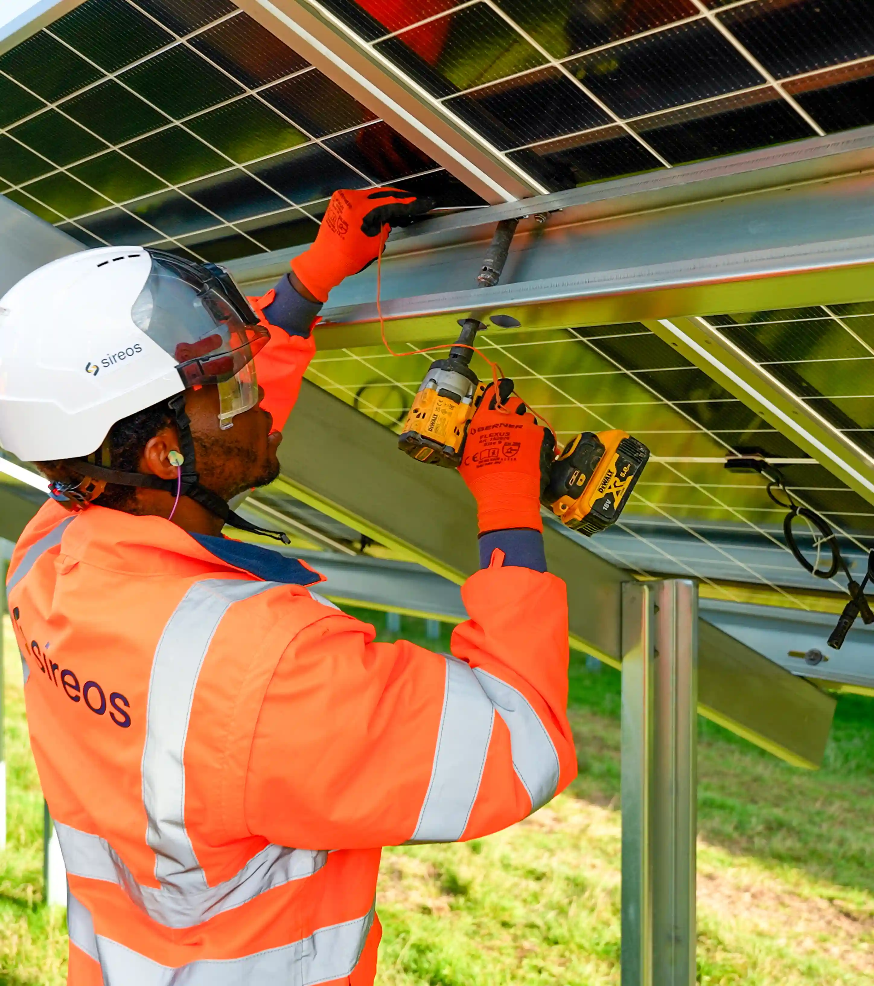 Technicien Sireos fixant des panneaux solaires sur leur structure