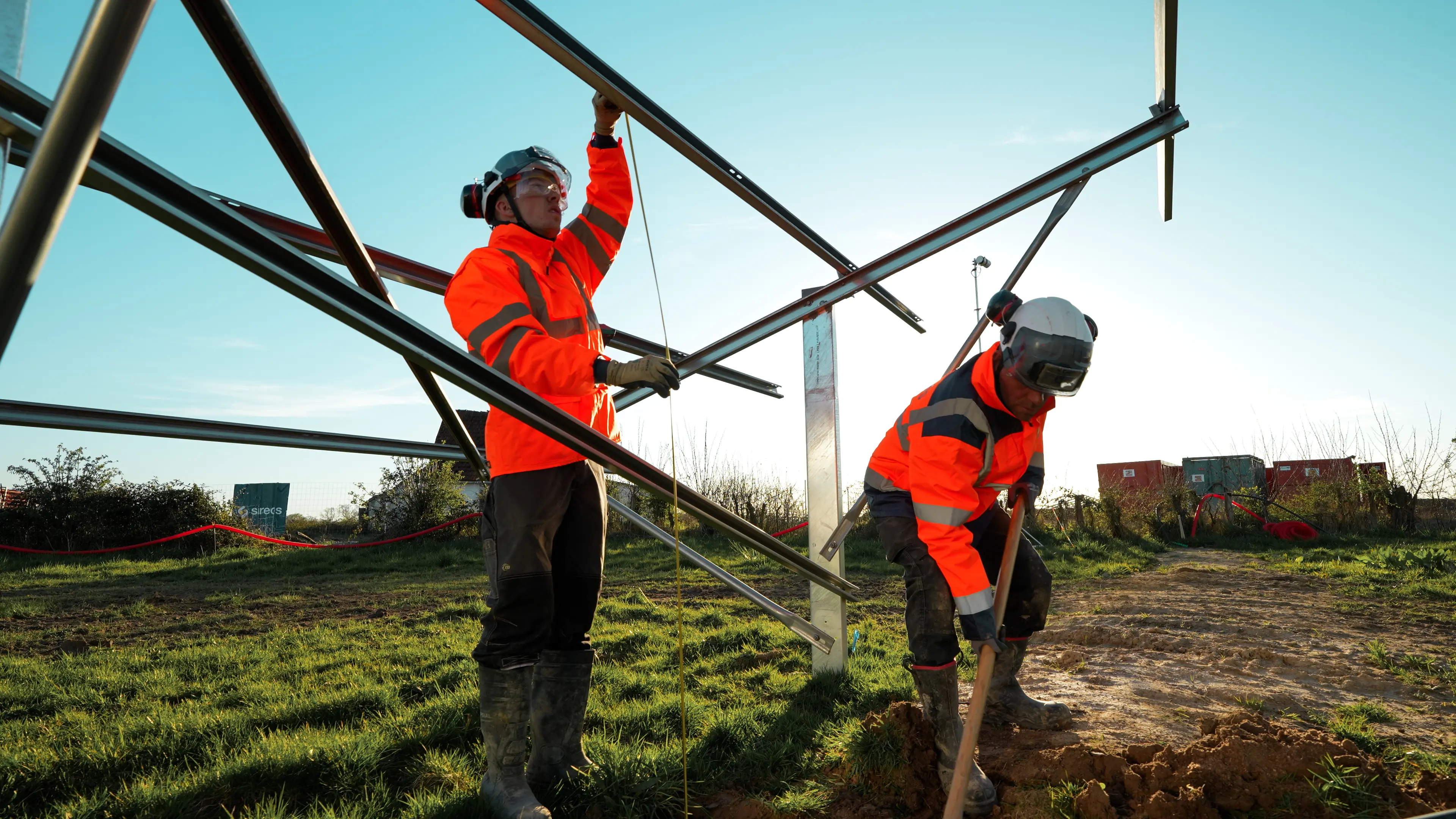 Deux techniciens Sireos assemblant la structure métallique d'une centrale photovoltaïque