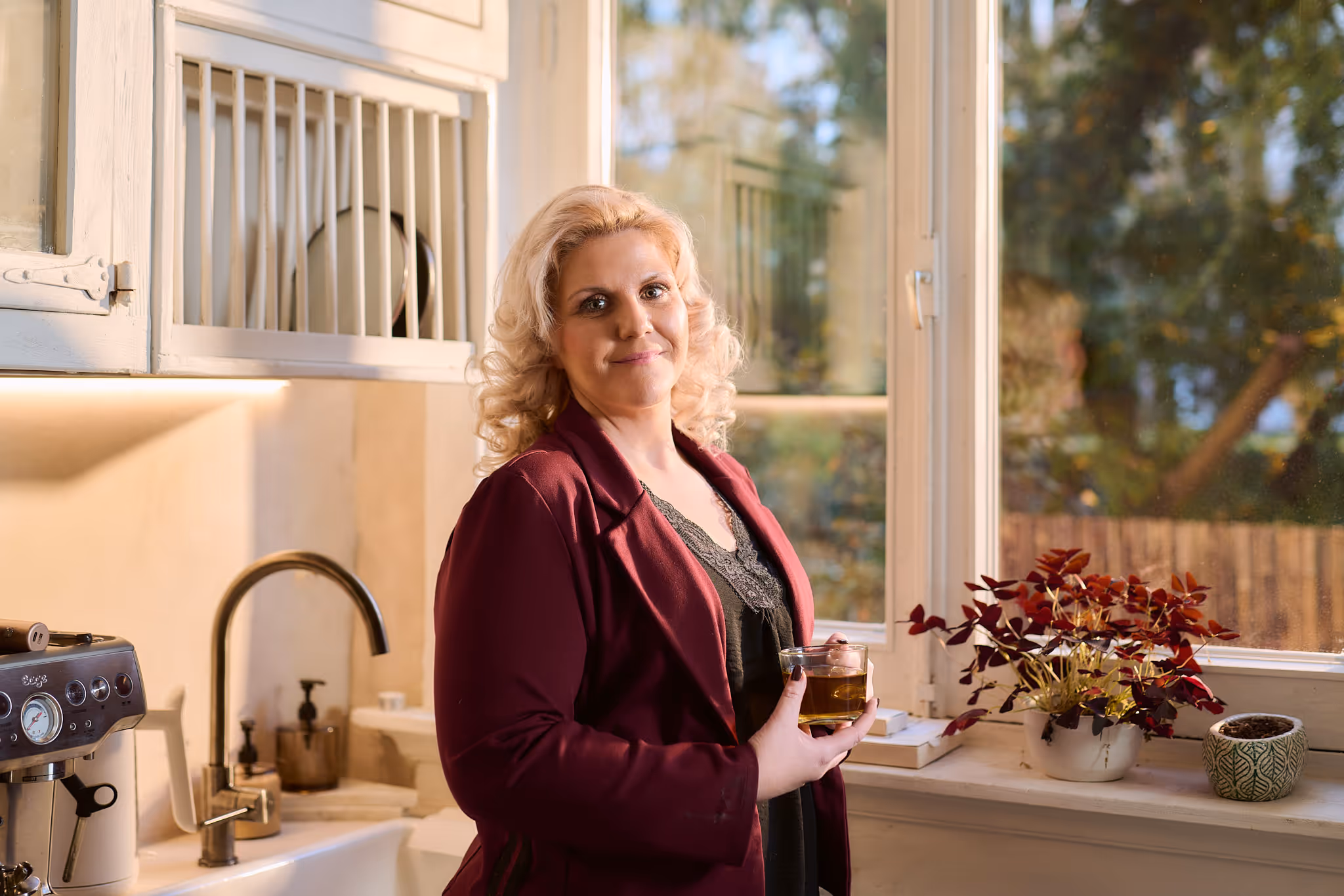 Een blije vrouw die een glas thee vasthoud