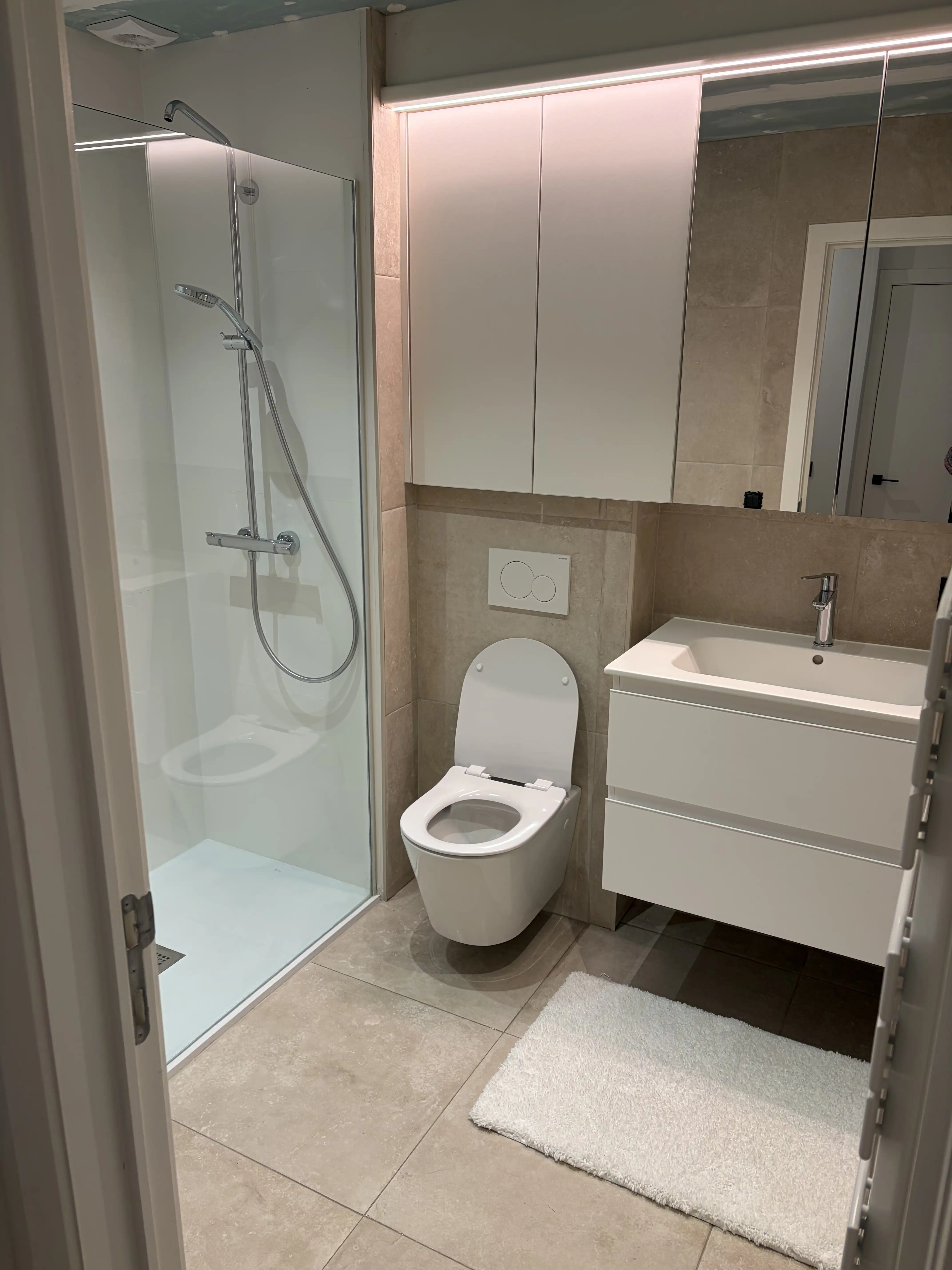 Gepoetste badkamer met douche en wastafel na de schoonmaak