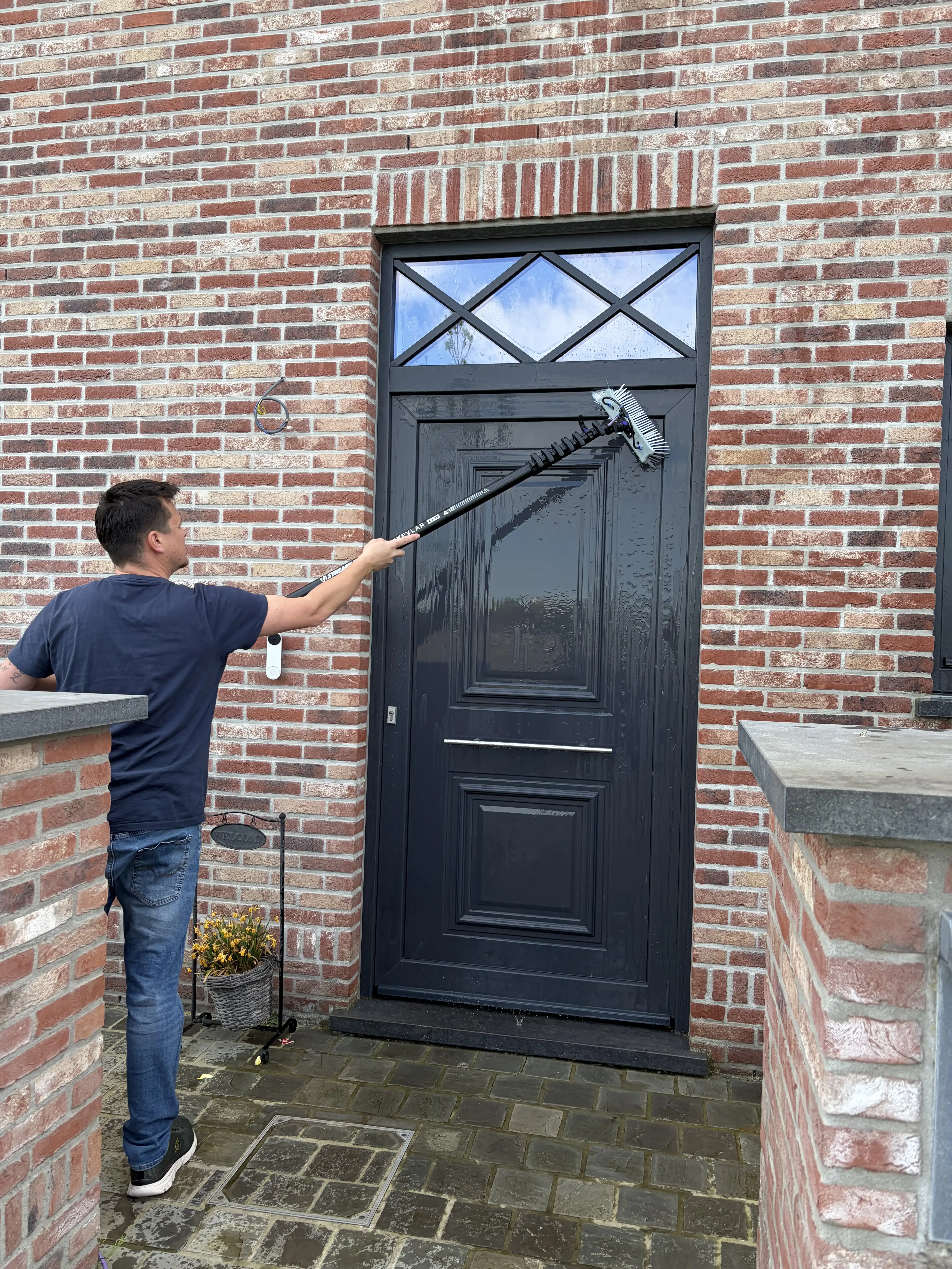 Kenneth reinigt de voordeur van een woning