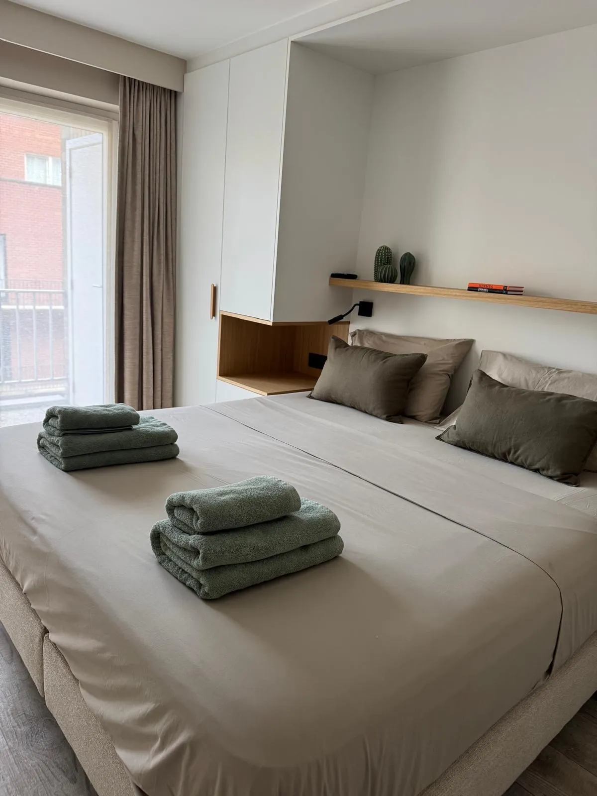 Opgemaakt bed met verse handdoeken, klaar voor de volgende huurders