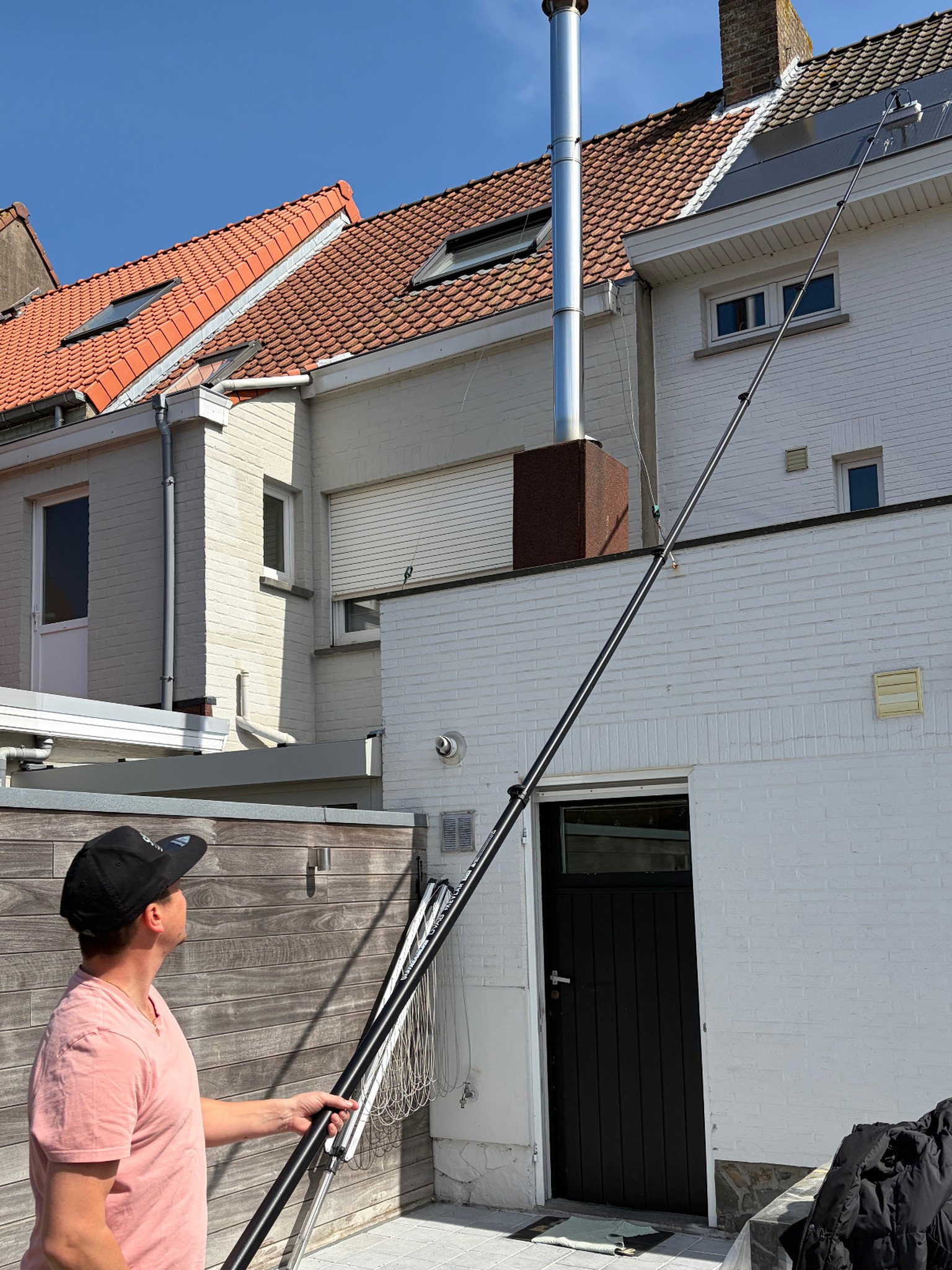Kenneth reinigt zonnepanelen met een telescoopsteel