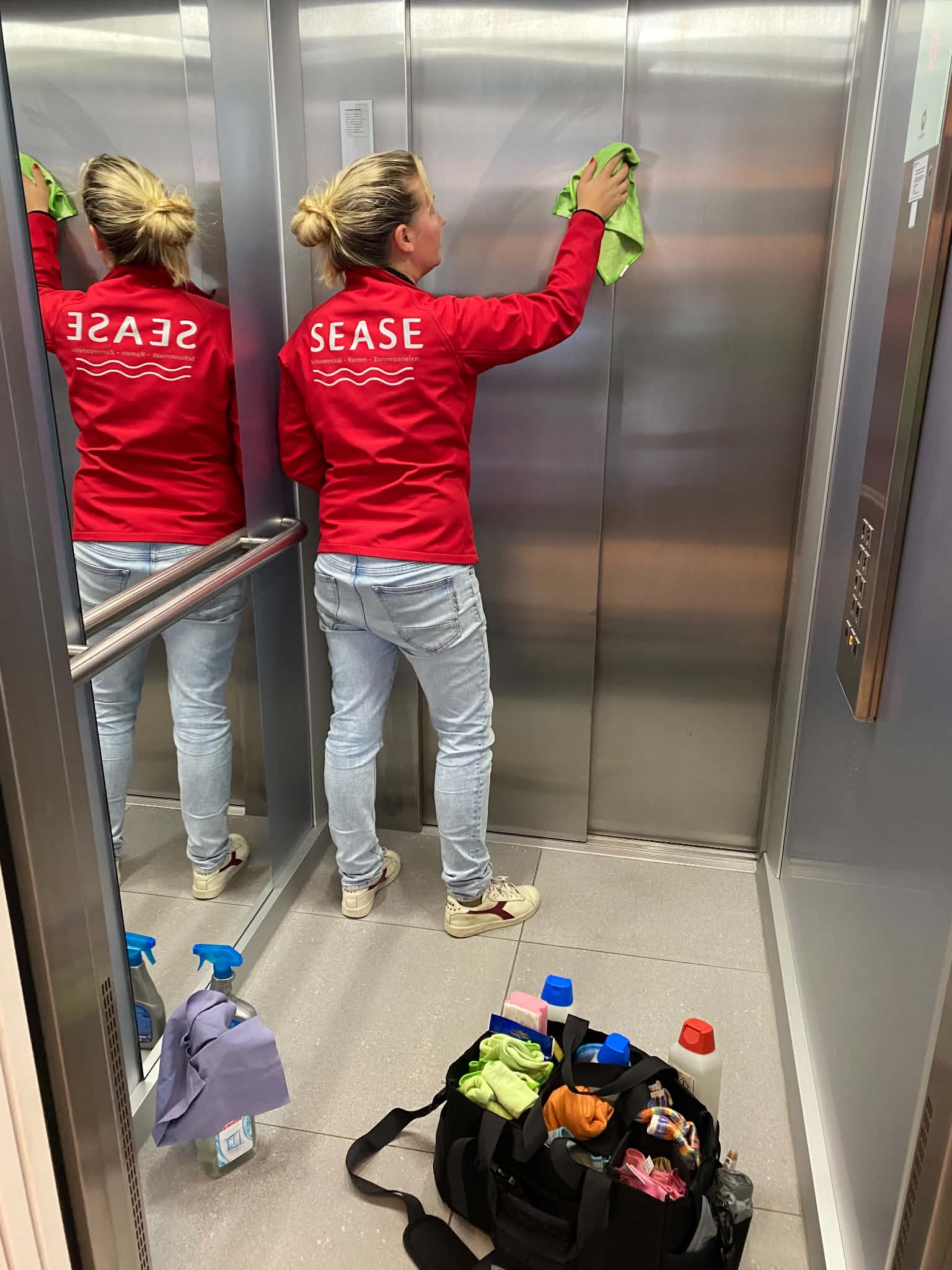 Lynn reinigt de binnenkant van een lift in een residentie