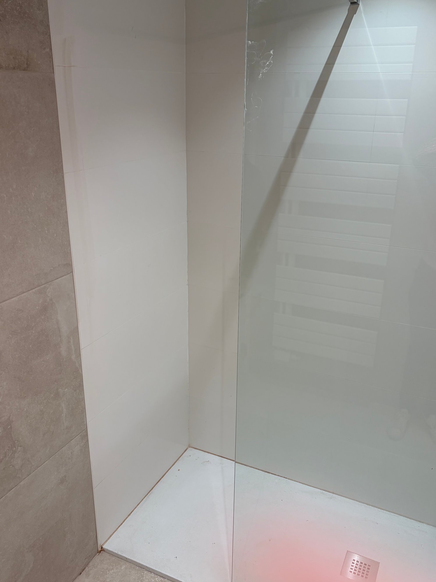 Douche met plekken op de douchewand voor de opkuis