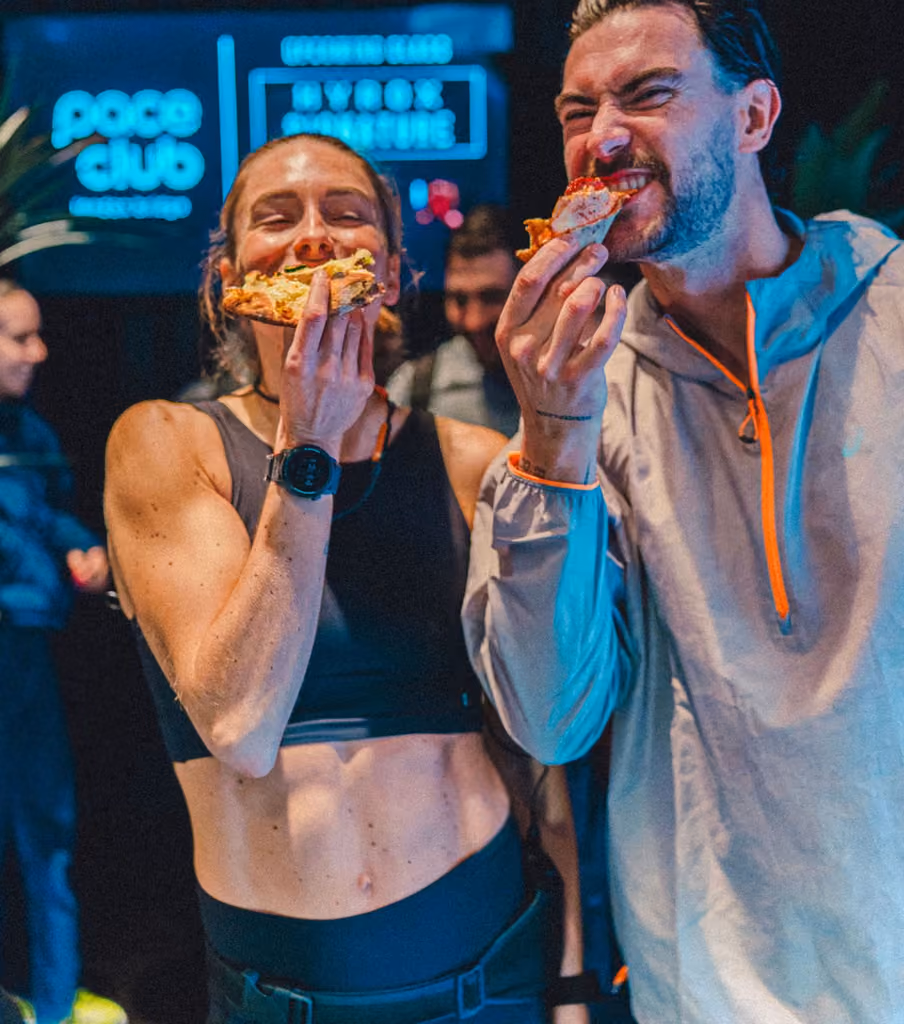 two athletes eating pizza at the London opening night