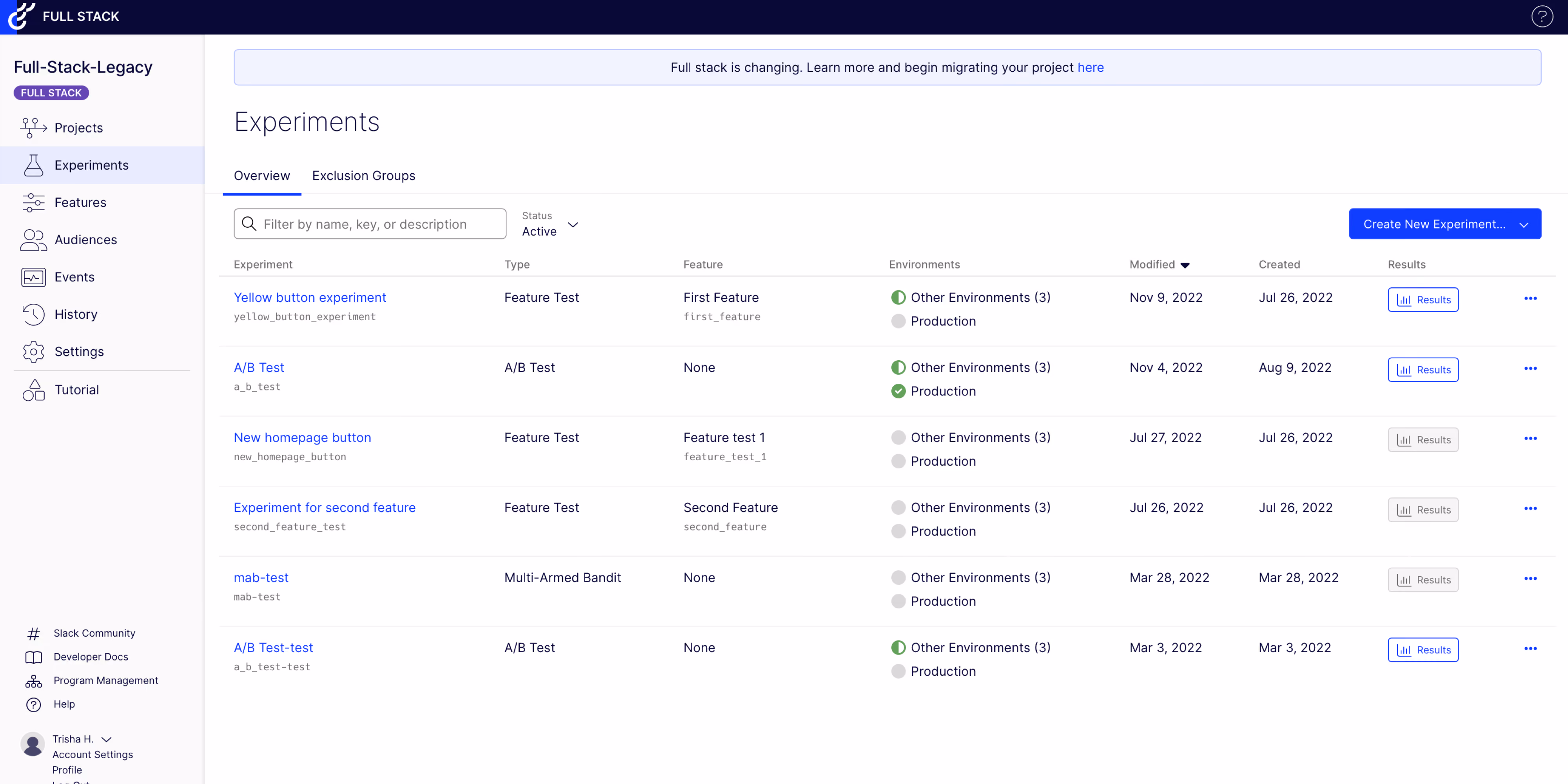 Dashboard of Full Stack software showing the Experiments section with a list of experiment names, types, features, environments, modified and created dates, and results status. Experiments include Yellow button experiment, A/B Test, New homepage button, Experiment for second feature, mab-test, and A/B Test-test. Sidebar menu displays options like Projects, Experiments, Features, Audiences, Events, History, Settings, and Tutorial. A banner at the top states, 'Full stack is changing. Learn more and begin migrating your project here.'
