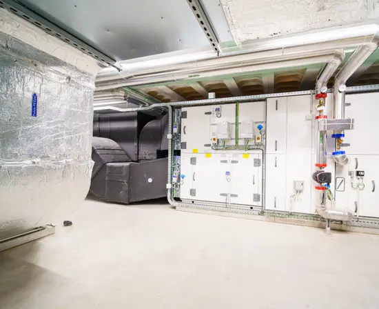 Chaufferie d'immeuble avec conduites calorifugées et vannes