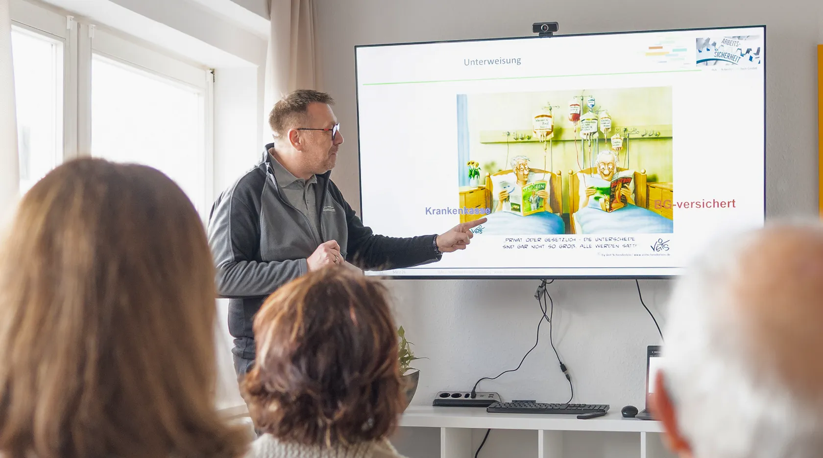 Unterweisung im Schulungsraum mit Präsentation am Bildschirm