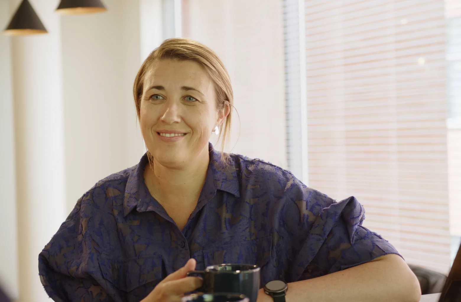 Valérie Crauwels, Head of People & Culture at Bnewable, in conversation with a colleague over coffee