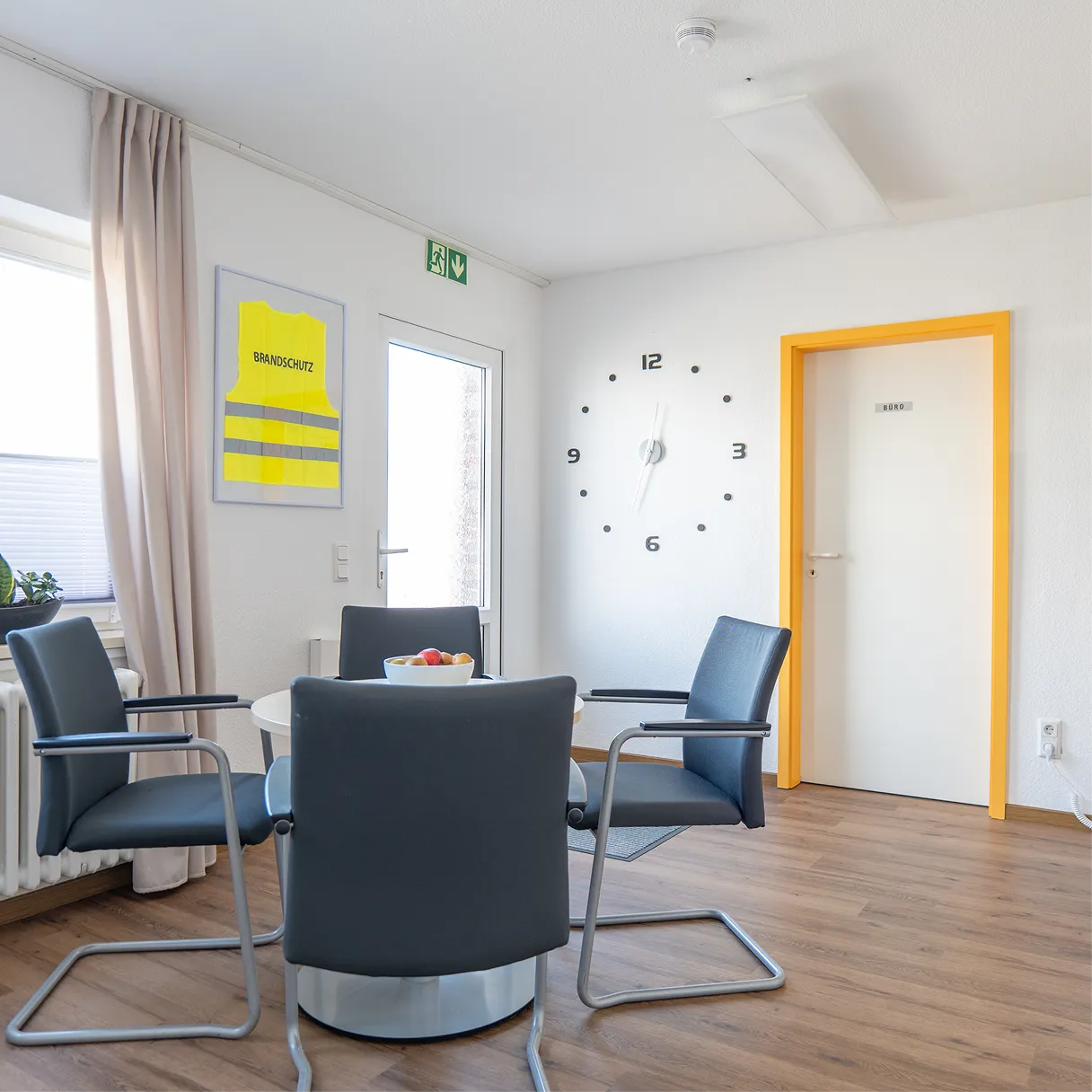Besprechungsraum mit rundem Tisch und vier Stühlen
