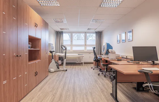 Untersuchungsraum mit Liege, Ergometer und Arbeitsplätzen