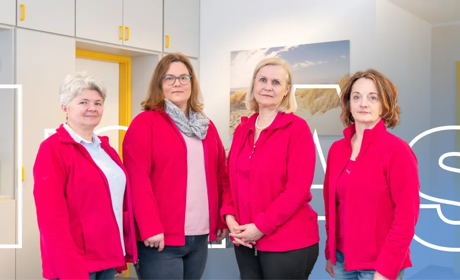 Vier Mitarbeiterinnen in roter Firmenkleidung