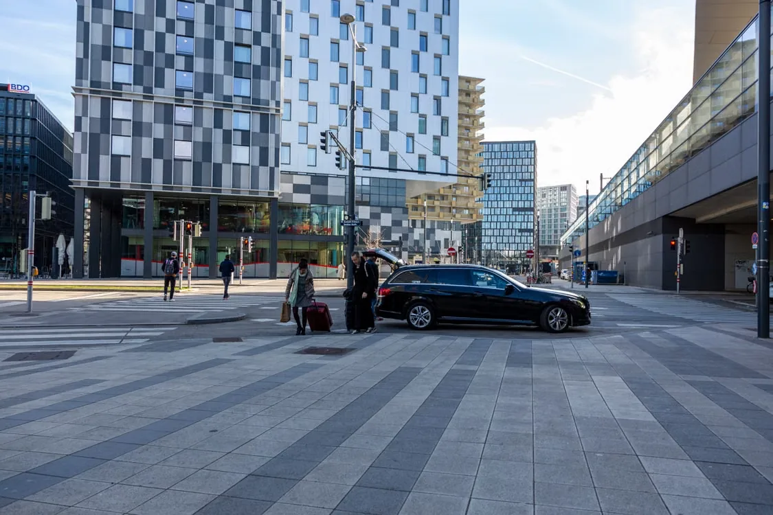 Chauffeur verstaut Gepäck vor einem Bürogebäude in der Innenstadt