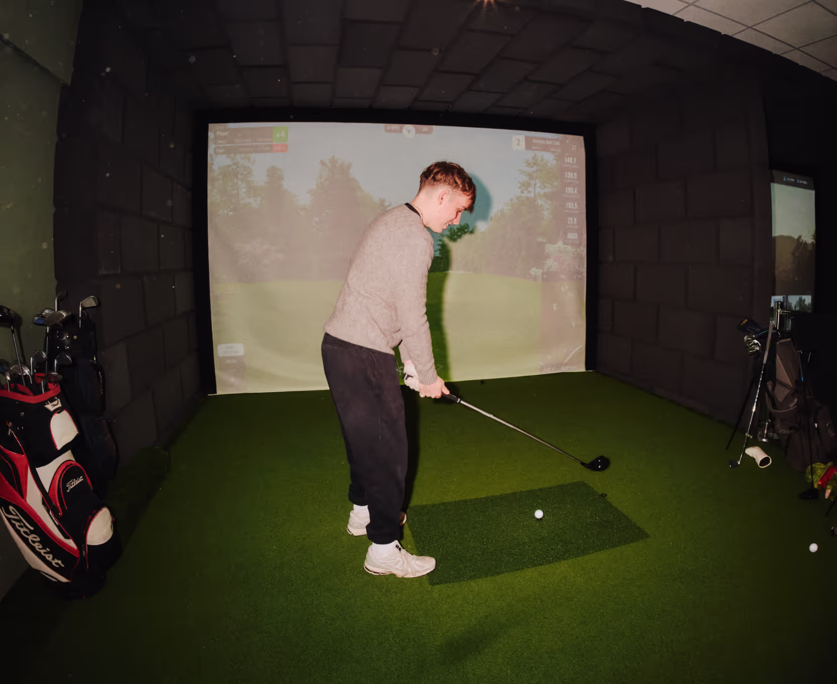 A customer enjoying a Social Sticks golf simulator in Bromsgrove