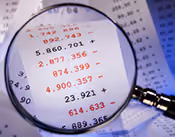 Lupe über einem Finanzdokument mit Zahlen und Beträgen, hervorgehobene rote Zahlen sind 892.743, 5.860.701, 2.877.356, 874.399, 4.900.357, 23.921, 641.633.