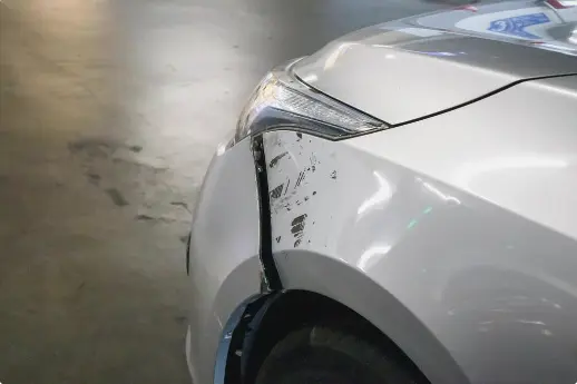 A car with accident damage on the bumper