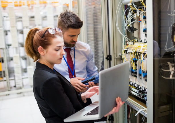 TQI team work together inside a server room beside racks of network equipment with cables.