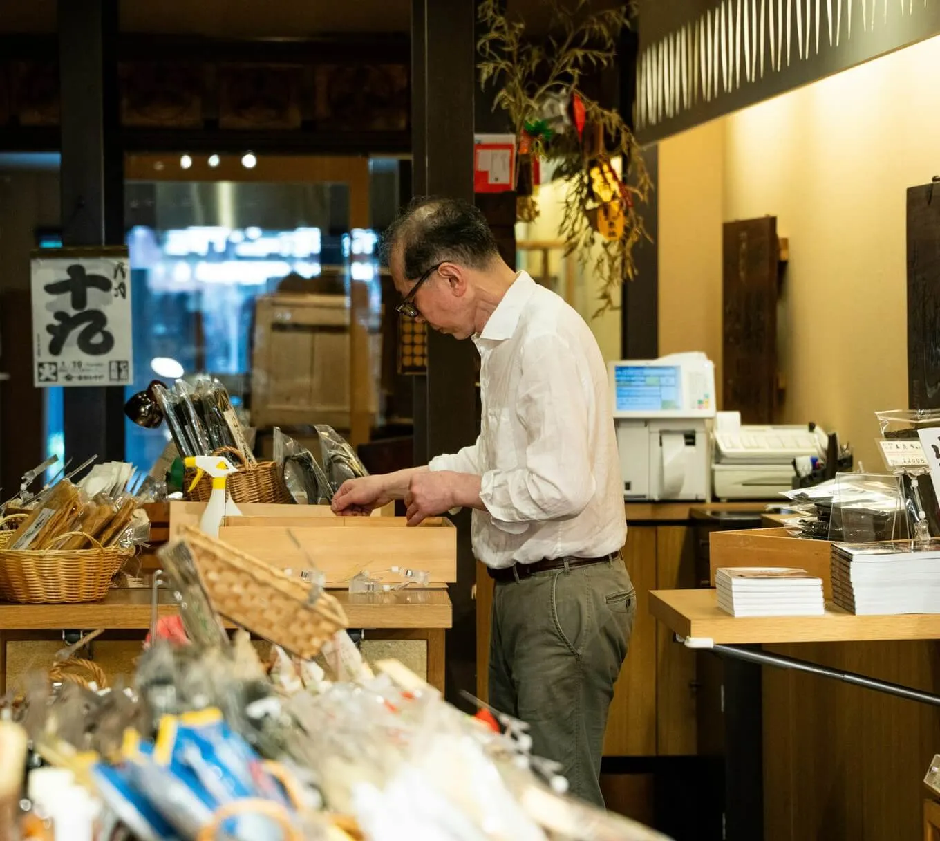 A shopkeeper working behind the counter of a small store