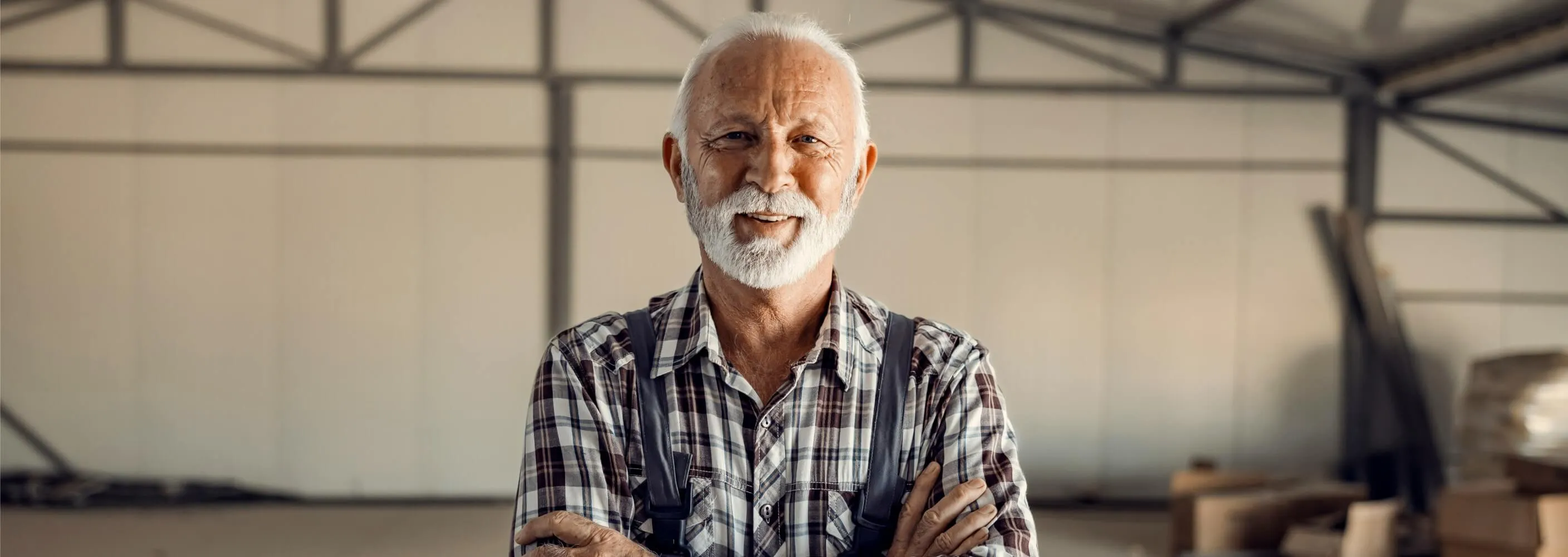 A small business owner standing in his workshop, arms folded