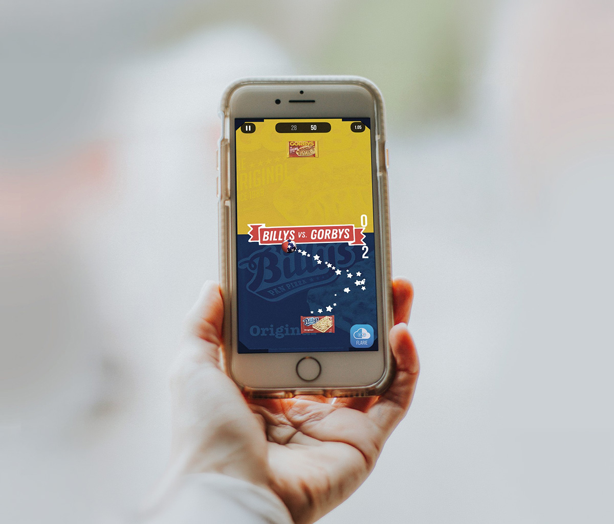 Hand som håller upp en mobil med ett kampanjspel