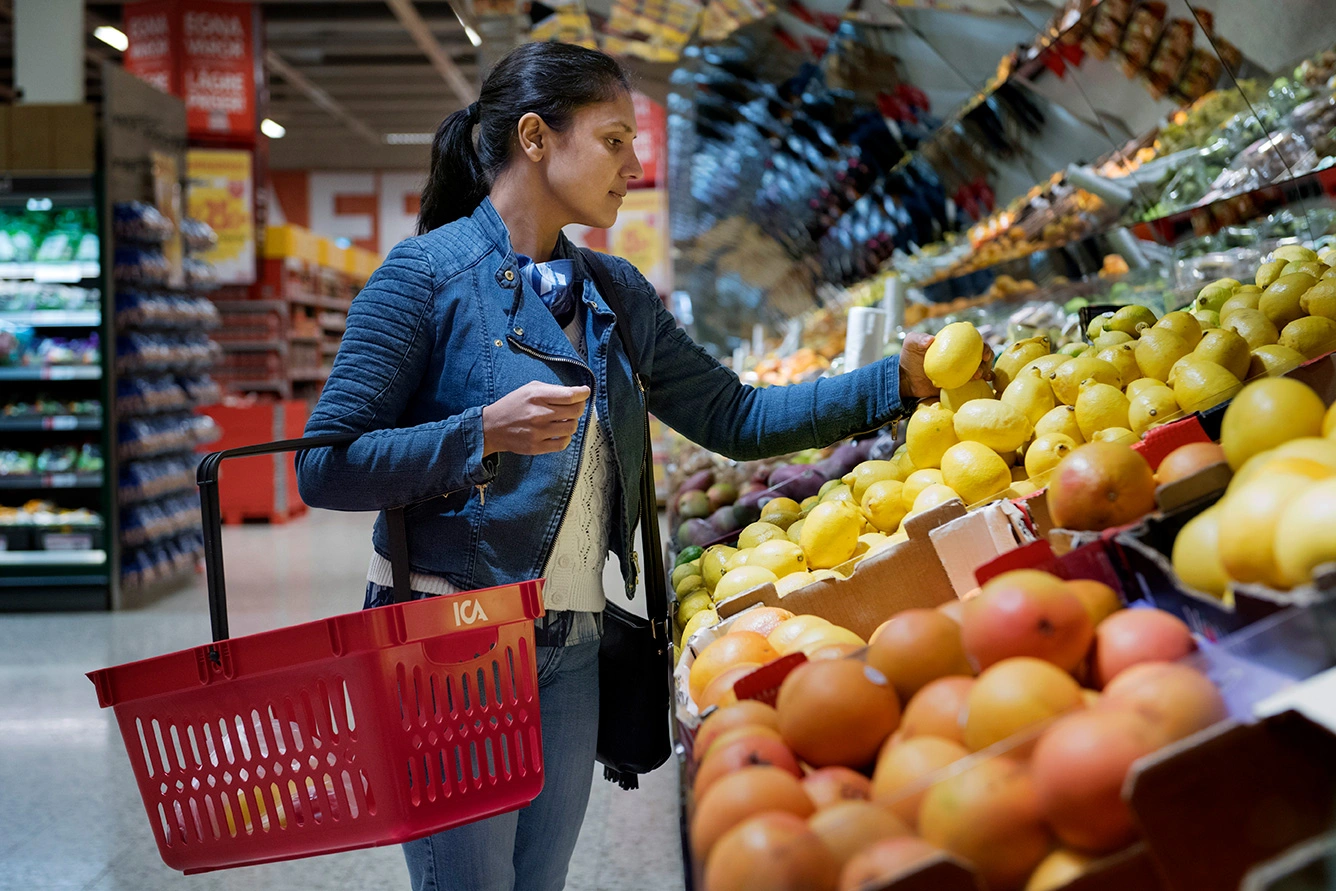 Kund med varukorg i frukt- och gröntavdelningen