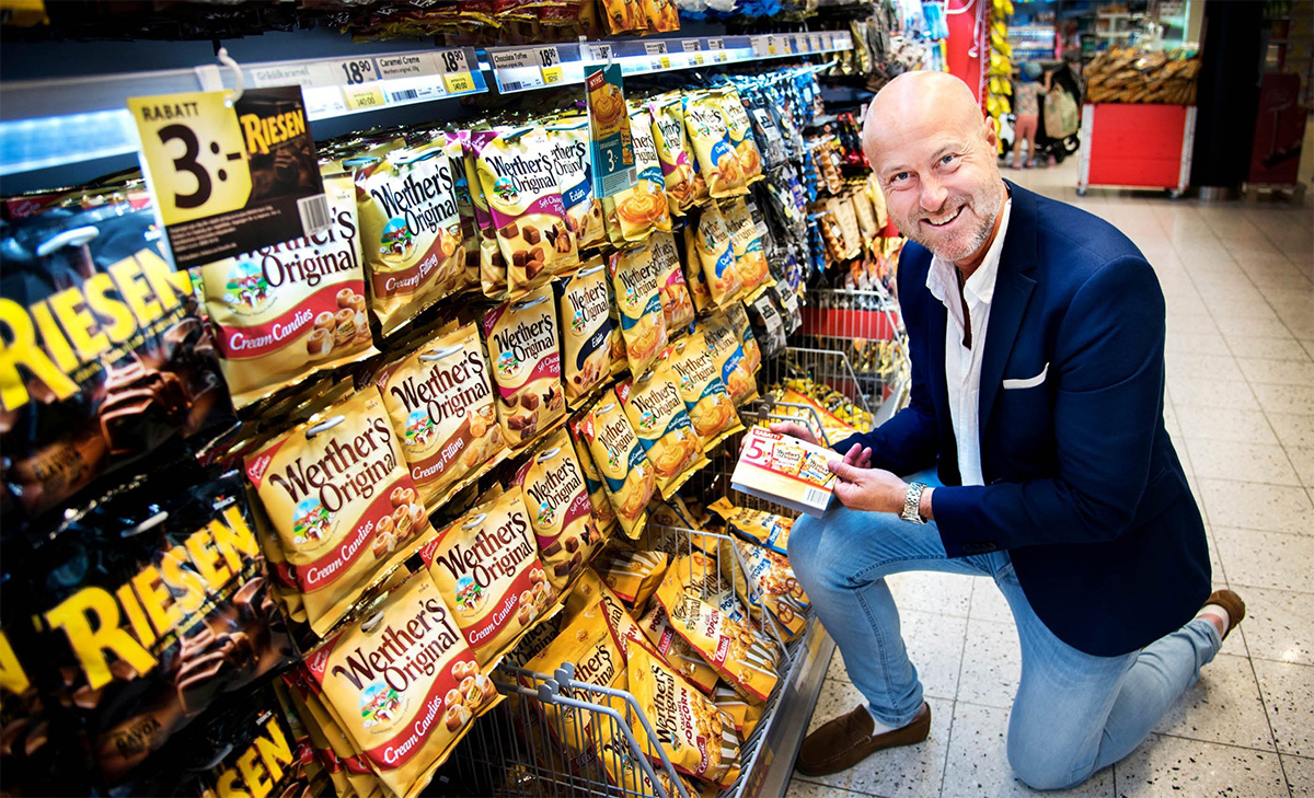 Man vid en hylla med godis och snacks