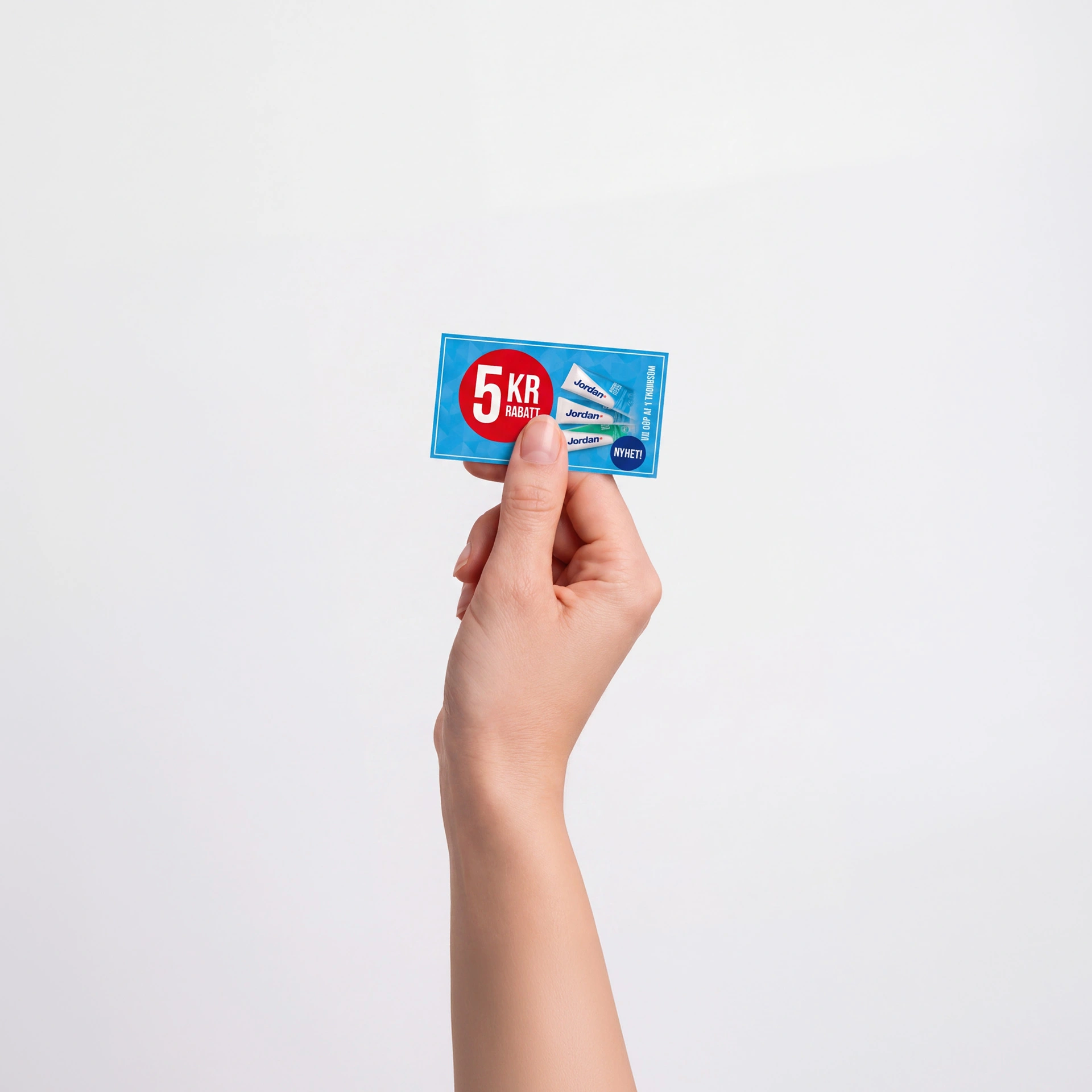 Hand som håller upp en tryckt kupong på 5 kronor