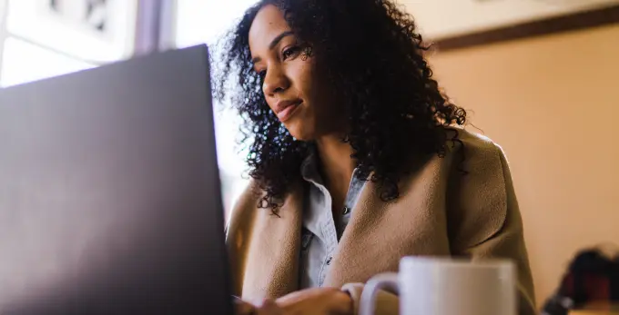 Dirigeante de petite entreprise consultant un ordinateur portable dans un bureau lumineux