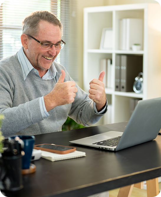 Man at a laptop giving a thumbs up