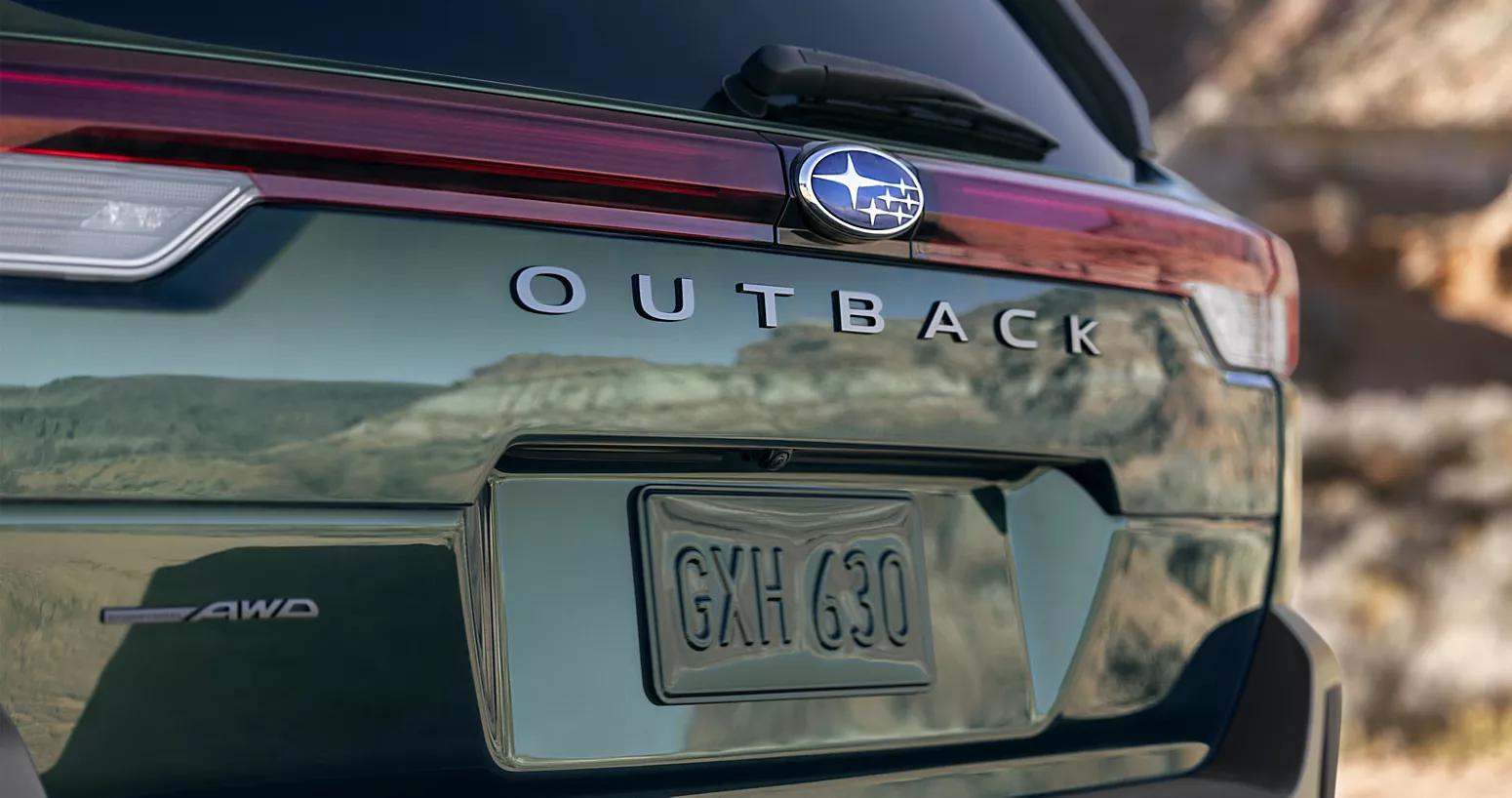 Rear view of green Subaru Outlander in outoor setting