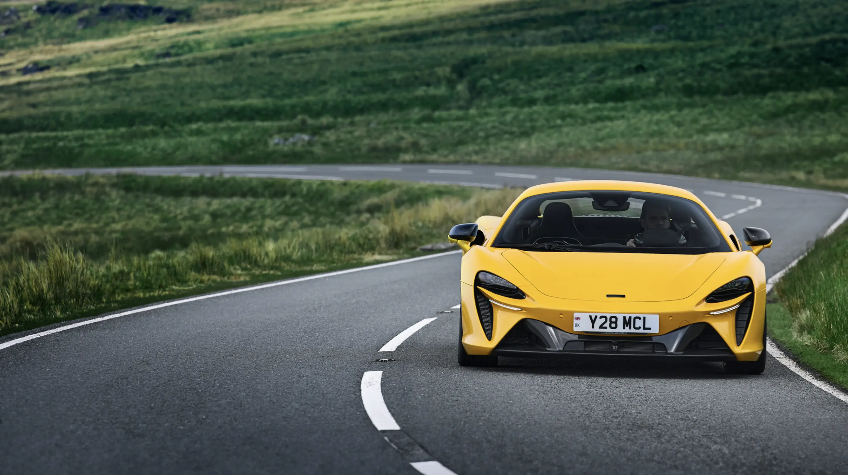 Yellow Lamborghini driving along a country road.