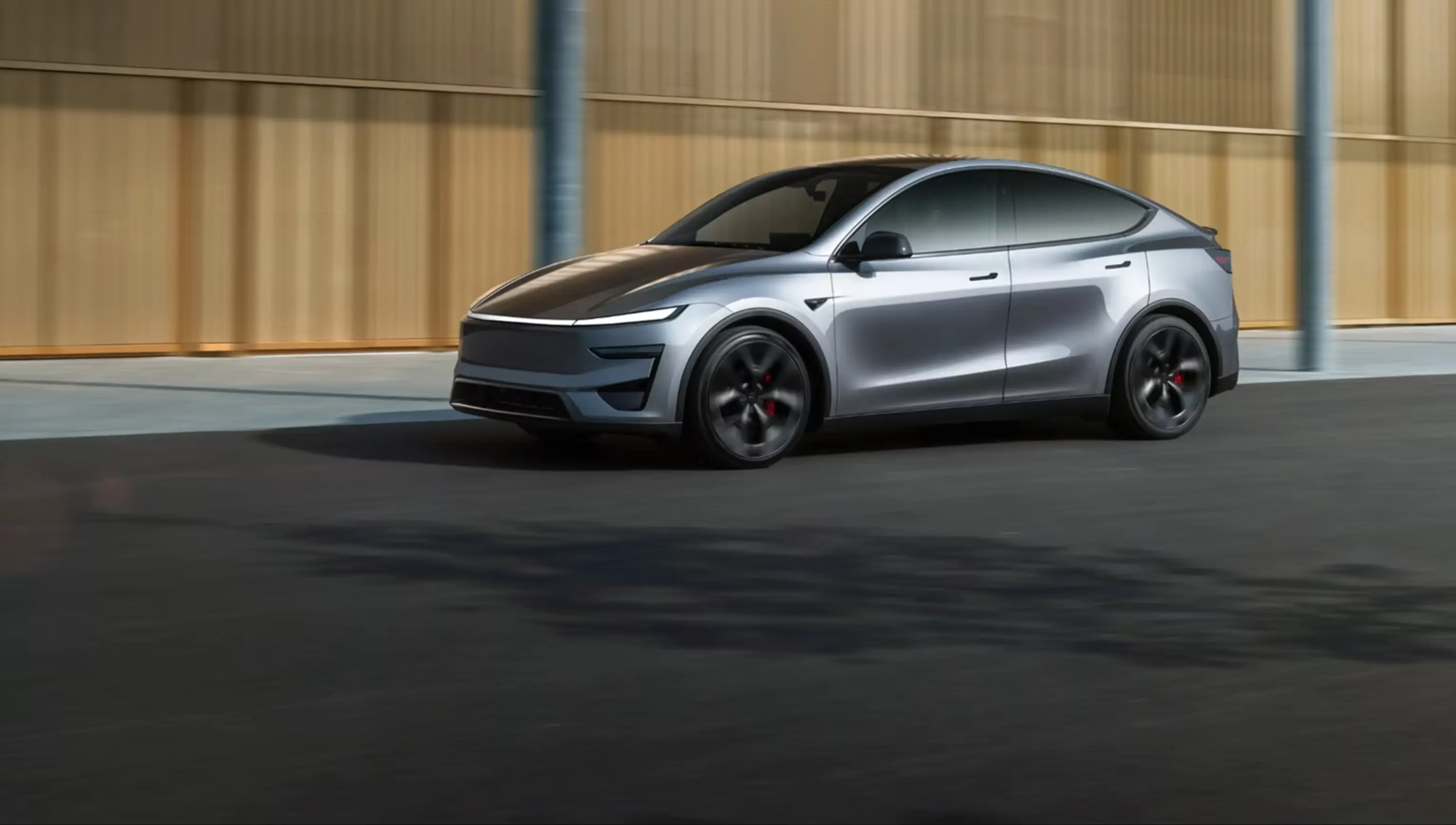 Silver Tesla hatchback driving along a city street.