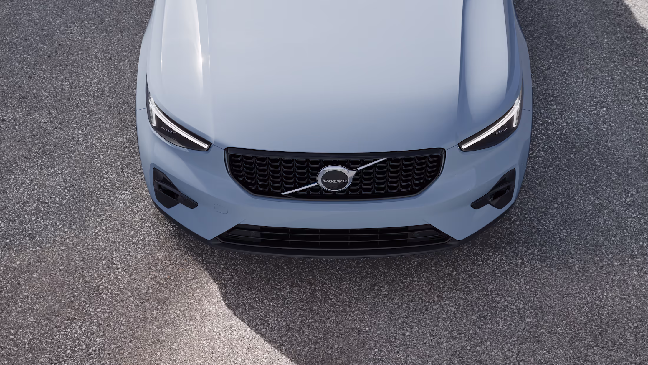 Hood and front fender of a white Volvo car.