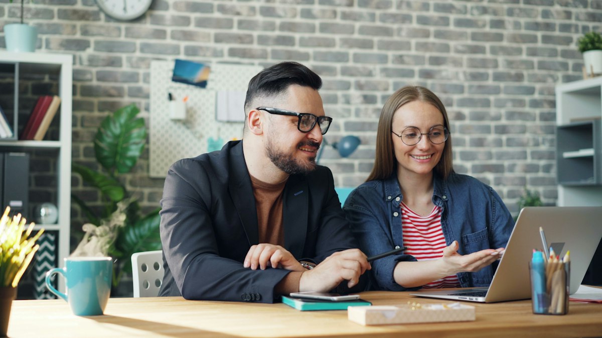 Freelance et client discutant ensemble devant un ordinateur portable, ciblage d'une mission