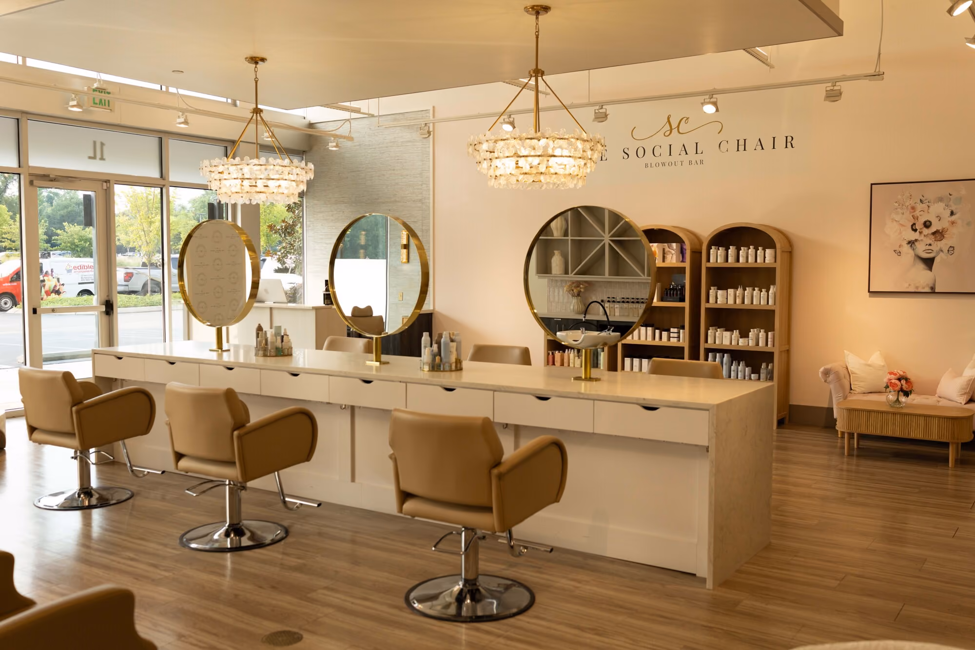 The Social Chair salon interior with styling stations, round mirrors and crystal chandeliers