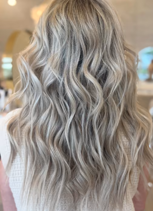 Long silver-blonde waves seen from behind after a blowout