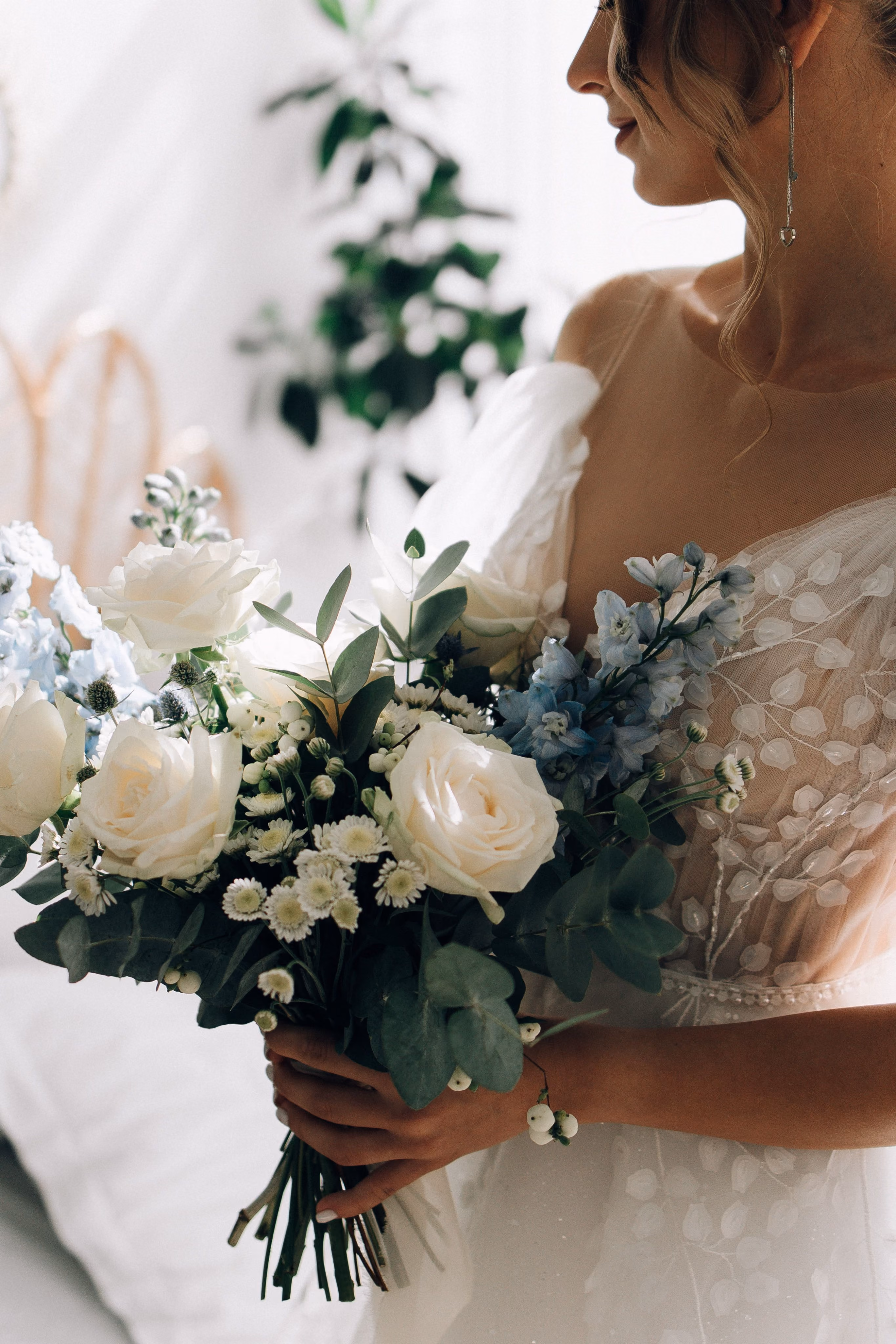 Bride holding a white rose and eucalyptus bouquet