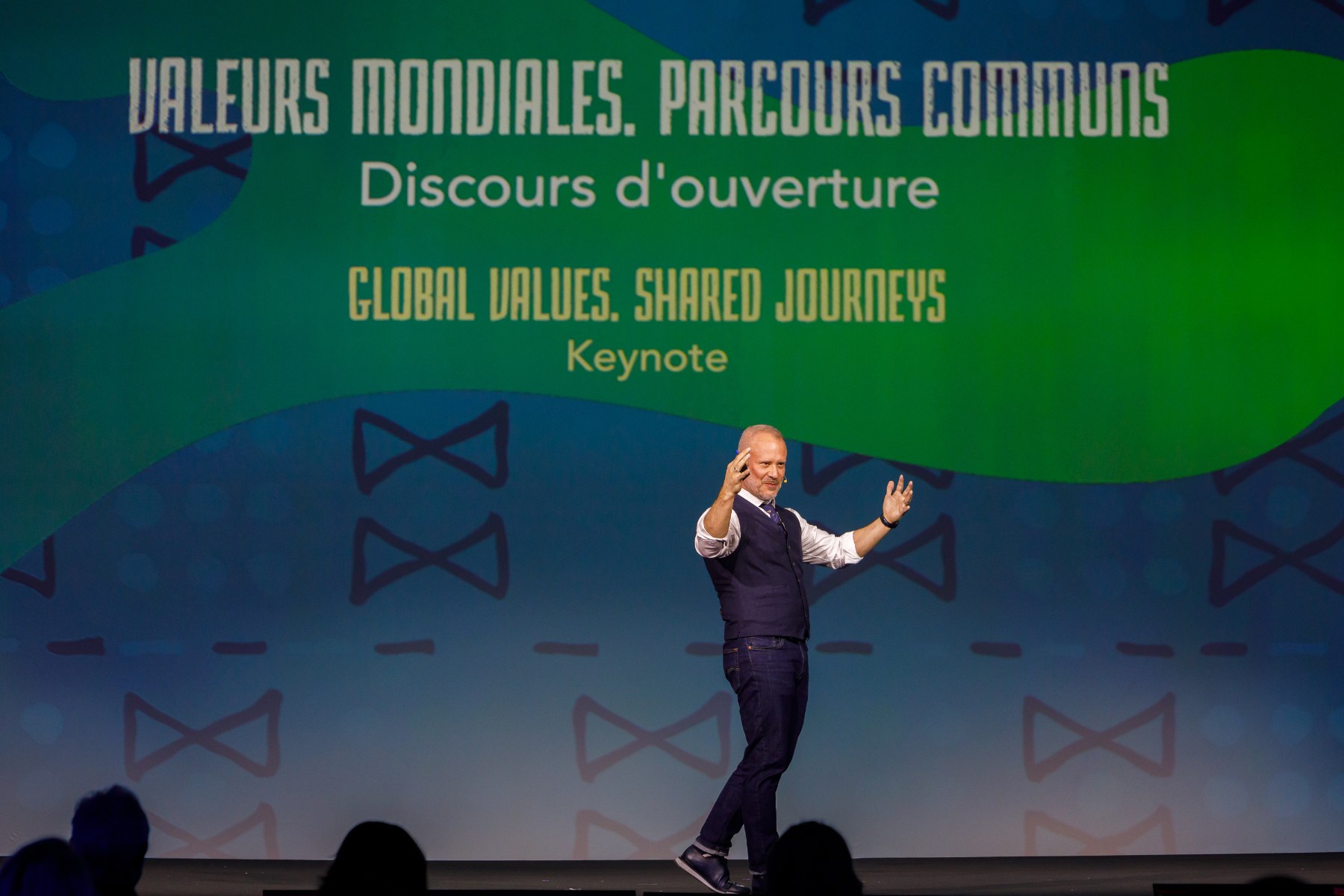David Allison on stage in front of a screen reading Global Values, Shared Journeys