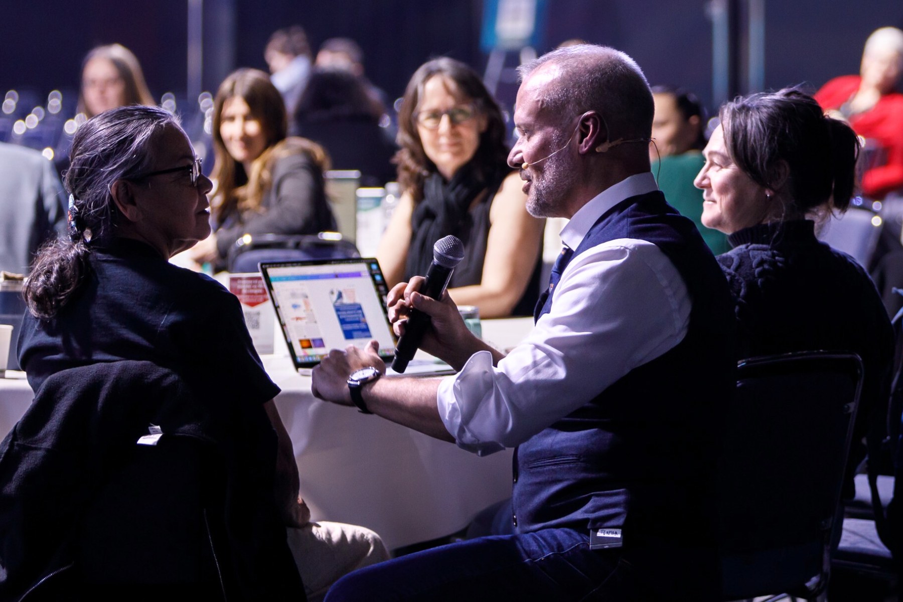 David Allison talking with event attendees at their table