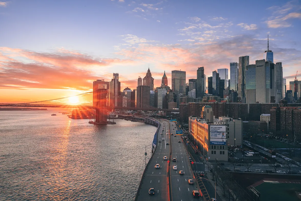 Aerial view of the Lower Manhattan skyline and FDR Drive at sunset
