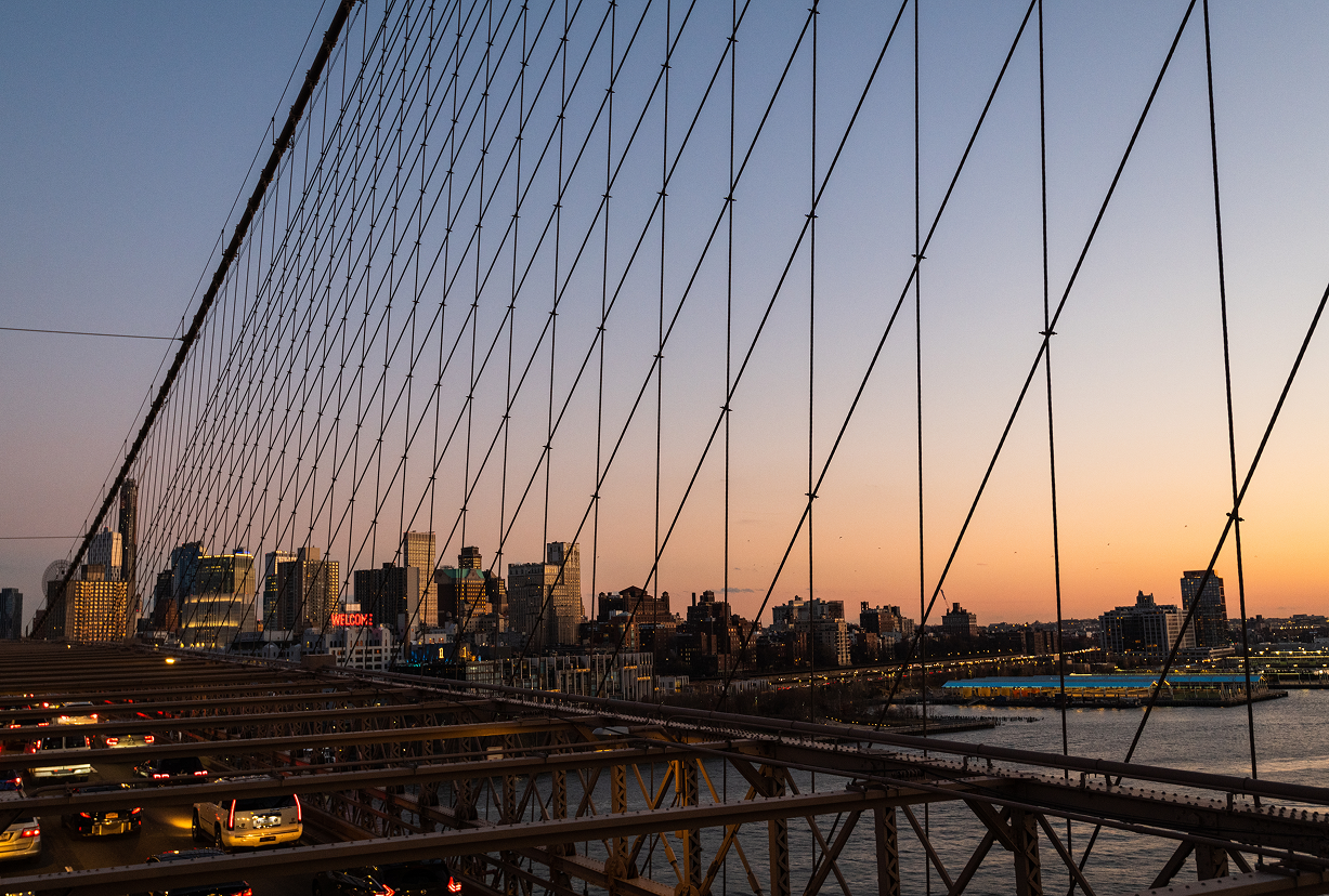 Brooklyn Bridge cables at sunset with the Manhattan skyline