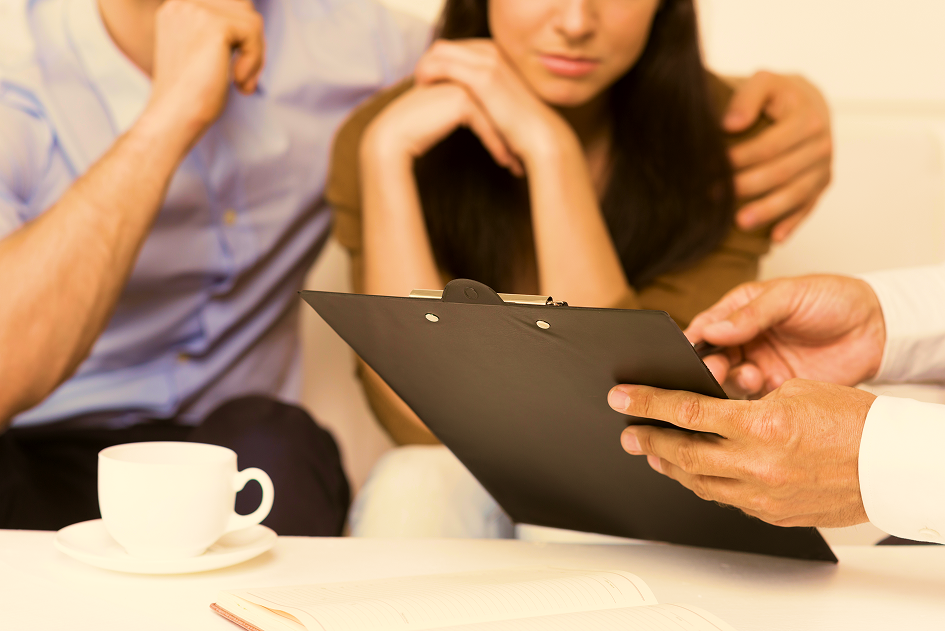 Couple reviewing documents on a clipboard with an advisor